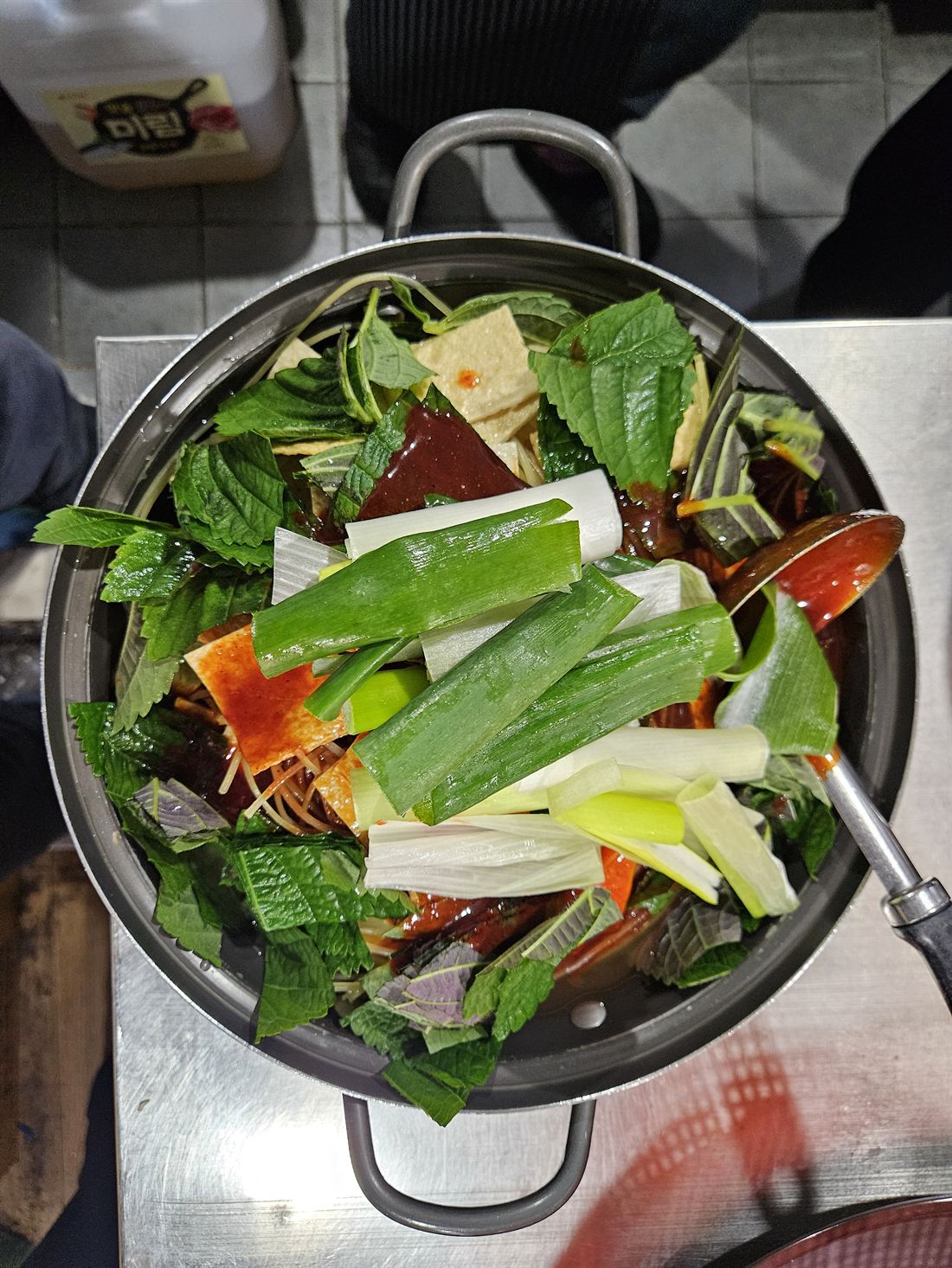 깻잎과 대파, 어묵 위에 특제 소스를 두른 즉석떡볶이 냄비