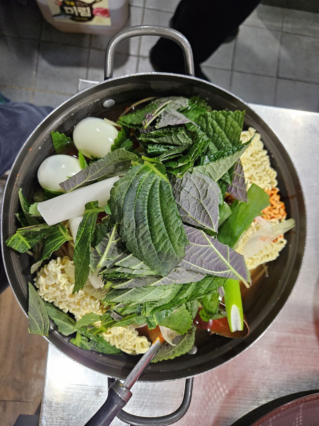 라면 사리와 계란, 깻잎을 수북하게 올린 즉석떡볶이
